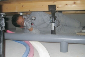 床下に潜って水道管のチェックを行う写真